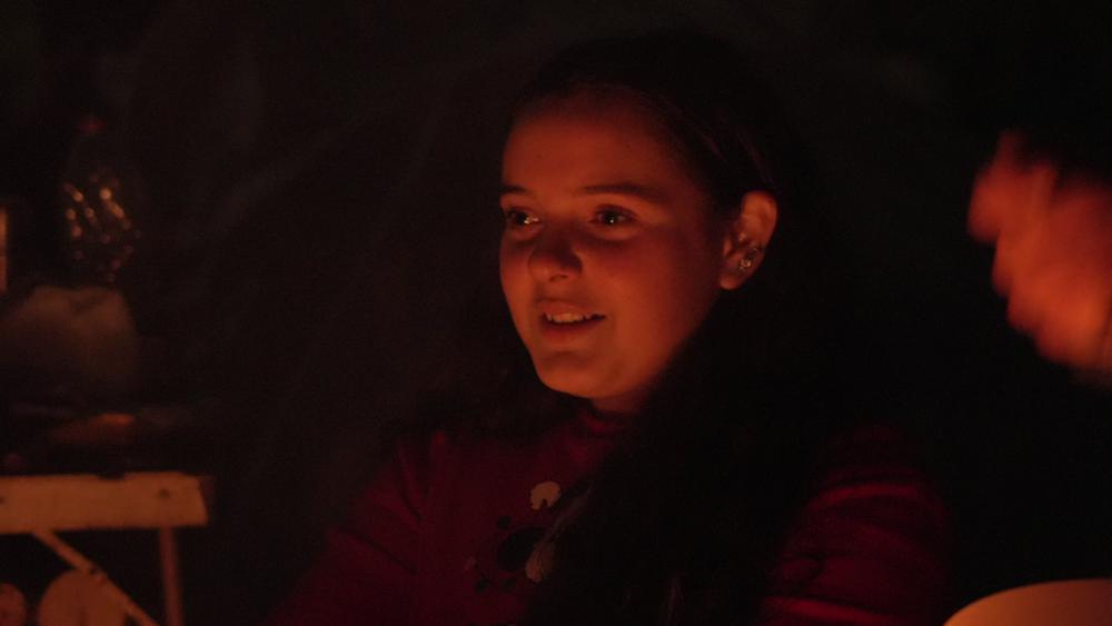 Isra savoure un dîner autour du feu. © Matis BILLER-GOEFFERS.