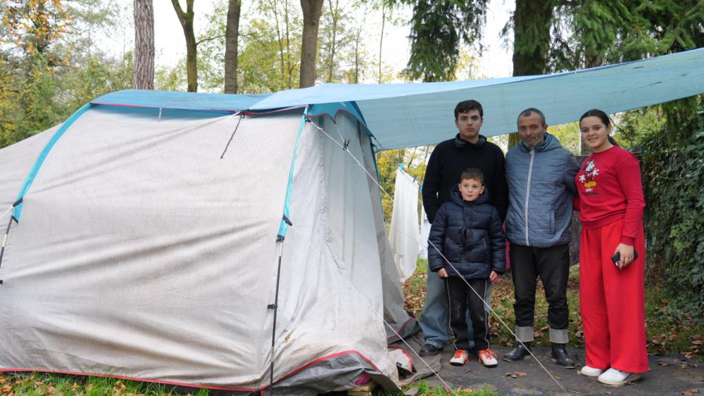 Isra, ses frères Erblil et Meris, et leur père Miri posent devant la tente principale de la famille. © Matis BILLER-GOEFFERS 