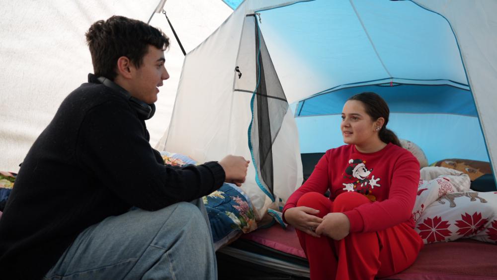 Isra et son grand frère, Meris, partagent un moment après les cours dans leur tente. © Matis BILLER-GOEFFERS